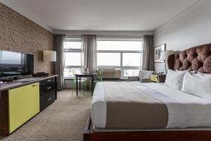 a hotel room with a bed and a television at Hotel Champlain in Quebec City