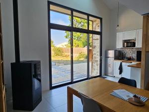 a kitchen with a dining table and a large window at La Petite Grange in Chavagnes-en-Paillers