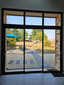 a room with a window looking out at a patio at La Petite Grange in Chavagnes-en-Paillers