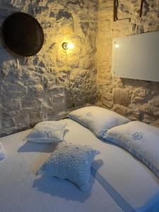 a bedroom with two pillows on a bed with a stone wall at Casa Giulia in Martina Franca