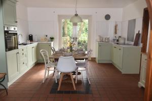 a kitchen with a table and chairs and a kitchen with white cabinets at The Hive, Maghera, Newcastle in Maghera
