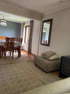 a living room with a table and a couch and a mirror at Casa full amoblada a pasos Jumbo Los Pablos in Temuco