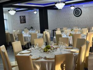 a dining room with tables and chairs with wine glasses at PENSIUNEA Ana in Buftea