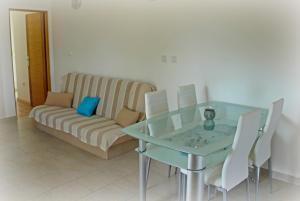 a living room with a glass table and a couch at Apartments Riva Povljana in Povljana
