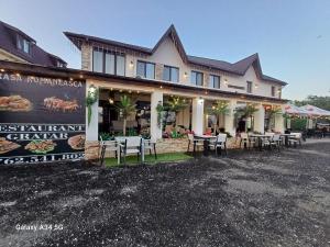 un ristorante con tavoli e sedie di fronte a un edificio di PENSIUNEA Ana a Buftea