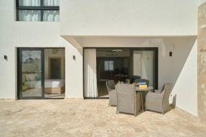 a patio with chairs and a table in a building at Luxury Escape Private Jacuzzi, Beach, Punta Cana SLEEP 5 in Punta Cana