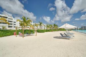 a beach with chairs and an umbrella and a building at Luxury Escape Private Jacuzzi, Beach, Punta Cana SLEEP 5 in Punta Cana