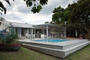 a house with a swimming pool and a patio at Sea Cottage in Port Shepstone
