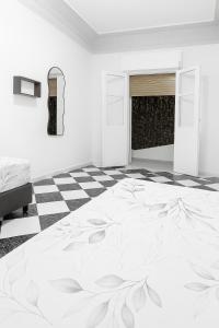 a white room with a bed and a checkered floor at Ftouh House 2 Heart of Tangier in Tangier +3 photos
