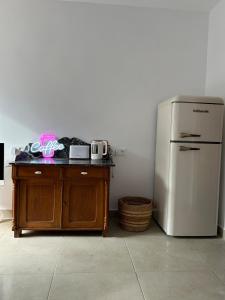 a kitchen with a refrigerator and a wooden table next to a counter at La barraca del pescador in Denia