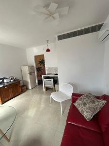 a living room with a red couch and a kitchen at La barraca del pescador in Denia