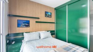 a bedroom with a bed and a green wall at Studio em Cotia com piscina e academia in Cotia