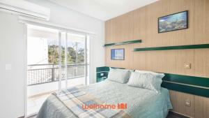 a bedroom with a bed and a large window at Studio em Cotia com piscina e academia in Cotia +13 photos