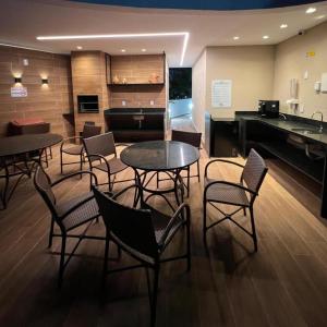 a room with tables and chairs and a piano at Capri Residence Luxo 02 quartos by Premium Reservas in Porto De Galinhas