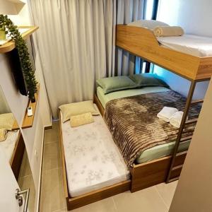 a small room with a bunk bed and a tv at Capri Residence Luxo 02 quartos by Premium Reservas in Porto De Galinhas +37 photos