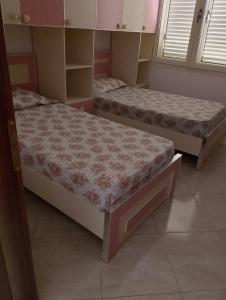 two beds in a room with twothirdsessions at Guest House Netile in Lushnjë +7 photos