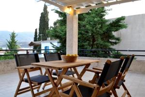 una mesa de madera y sillas en un patio en Villa Yiotevi, en Poros