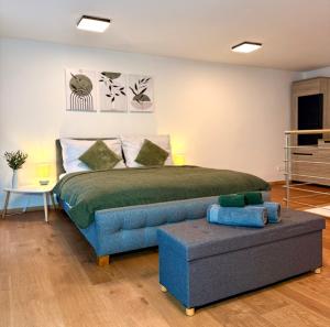 a bedroom with a bed and a blue couch at Apartmán Pražská - Budweis in České Budějovice