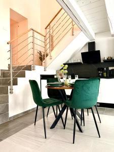 a dining room with a table and green chairs at Apartmán Pražská - Budweis in České Budějovice +19 photos