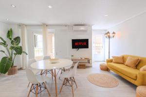 a living room with a yellow couch and a table at Downtown apartment near the beach and airport in Santa Pola
