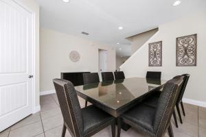 a dining room with a glass table and black chairs at Charming Home Near Disney With Game Room And Waterpark & Resort Access At Encore Resorts Reunion - 7592Mr in Kissimmee +27 photos