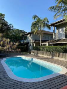 a swimming pool in front of a house at Vila Tiare Maresias in Maresias