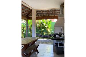 a kitchen with a wooden table and a hammock at Vila Tiare Maresias in Maresias