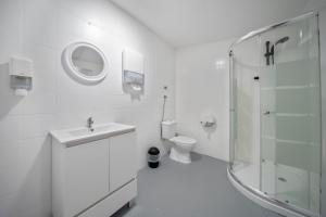 un bagno bianco con lavandino e WC di Plaza Inn Hostel & Rooms a Faro Altre 56 foto