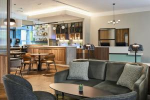 a living room with a couch and tables and a bar at Residence Inn by Marriott Edinburgh in Edinburgh