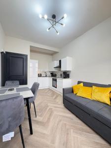 Una sala de estar con un sofá negro y una mesa. en 3BR West End Flat w Free Parking, en Glasgow