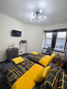 Dos camas en una habitación con sábanas amarillas y negras. en 3BR West End Flat w Free Parking, en Glasgow 33 fotos más