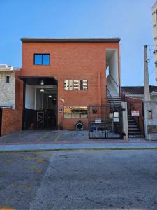a brick building with a stairway leading into a garage at Ótimo Apartamento in São José