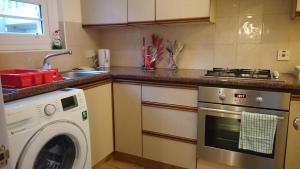 a kitchen with a washer and a washing machine at Mayville House Flat in Cheltenham
