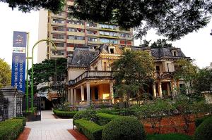 a large building with a garden in front of it at Hotel Stela - A 2 min do Metrô Paraíso e Poucos Passos da Av Paulista in São Paulo