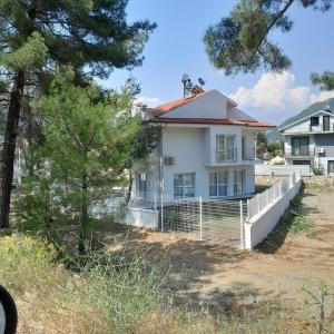 a white house with a red roof at Villa Belce & Bloom - Üzümlü in Fethiye