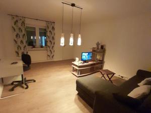 a living room with a couch and a tv at Goldstück im Grünen in Bad Schonborn