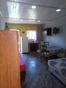 ein Zimmer mit Küche, Tisch und Kühlschrank in der Unterkunft CABAÑITAS del sur in Mar del Plata
