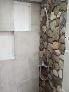 ein Bad mit einer Dusche und einer Steinmauer in der Unterkunft CABAÑITAS del sur in Mar del Plata