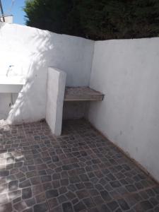 eine weiße Wand mit einer Bank neben einem Waschbecken in der Unterkunft CABAÑITAS del sur in Mar del Plata