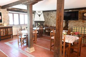 a dining room with tables and chairs and a tv at La casa del agua Cantabria in Ampuero