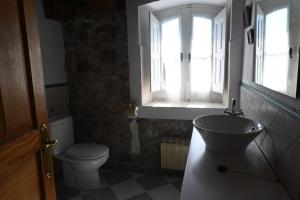 a bathroom with a sink and a toilet and a window at La casa del agua Cantabria in Ampuero +34 photos
