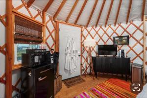a room with a refrigerator and a desk in a yurt at Rustic Luxe Yurt- Unit #1 in Woodway
