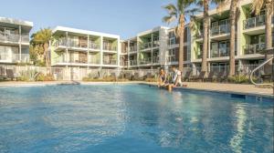 two people sitting on the edge of a swimming pool in a resort at Charming Bliss By the Ocean LUXE 2bd 2ba MDR in Los Angeles