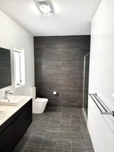 a bathroom with a toilet and a sink at 500m to Werri Beach - The Palms in Gerringong