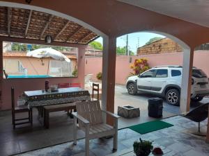 eine Terrasse mit einem Tisch und einem auf einem Parkplatz geparkten Auto in der Unterkunft Casa de Praia Mosqueiro Chapéu Virado in Belém
