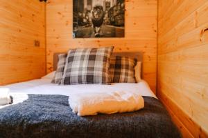 ein Schlafzimmer mit einem Bett in einem Holzzimmer in der Unterkunft Butterfly Lodge in Headcorn