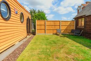 a backyard with a fence and a table and chairs at Butterfly Lodge in Headcorn