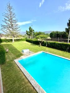 a large blue swimming pool in a yard at CAL QuEROL LlíViA 1- reformado con piscina en el centro in Llivia