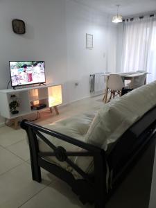 a living room with a bed and a tv at Depa pleno centro Santa Fe in Santa Fe