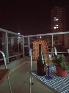 a bottle of wine and a glass on a table on a balcony at Depa pleno centro Santa Fe in Santa Fe +4 photos